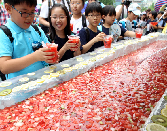 정남진 물축제가 오는 27일 부터 다음 달 2일 까지 장흥읍 탐진강과 편백숲 우드랜드 일원에서 열린다. 장흥군과 축제추진위는 이를 홍보하기 위해 17일 서울 청계광장에서 이벤트를 진행했다. 사진은 이날 열린 2012인분 수박화채 무료시식 모습. 연합뉴스