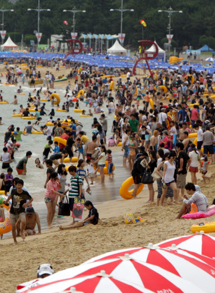 22일 부산 해운대해수욕장을 찾은 피서객들이 물놀이를 즐기거나 파라솔 아래에서 더위를 식히고 있다. 이날 해운대해수욕장에는 25만명의 피서객들이 몰려 더위를 식혔다. 연합뉴스