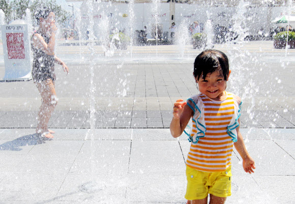 24일 오전 전남 여수엑스포 행사장에서 한 어린이가 분수 속을 뛰어다니며 더위를 식히고 있다. 연합뉴스