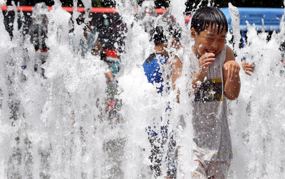 전국 대부분 지방 낮 최고 기온이 30도를 넘는 불볕더위가 이어진 24일 오후 서울 광화문 광장에서 어린이들이 물놀이하며 더위를 식히고 있다. 연합뉴스
