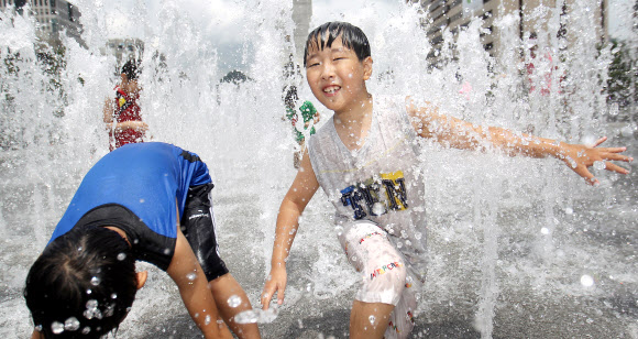 전국 대부분 지방 낮 최고 기온이 30도를 넘는 불볕더위가 이어진 24일 오후 서울 광화문 광장에서 어린이들이 물놀이하며 더위를 식히고 있다. 연합뉴스