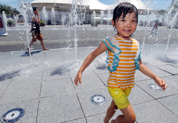24일 오전 전남 여수엑스포 행사장에서 한 어린이가 분수 속을 뛰어다니며 더위를 식히고 있다. 연합뉴스