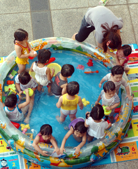 24일 울산시교육청에서 교육청 어린이집 어린이들이 간이 풀장에서 물놀이하며 더위를 피하고 있다. 연합뉴스