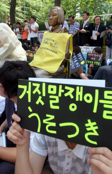 25일 오후 서울 종로구 중학동 일본대사관 앞에서 열린 제1032차 일본군 위안부 문제해결을 위한 정기수요시위에서 참석자들이 피켓을 들고 있다. 연합뉴스