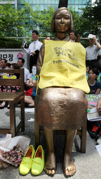 25일 오후 서울 종로구 중학동 일본대사관 앞에서 열린 제1032차 일본군 위안부 문제해결을 위한 정기수요시위에서 시민들이 위안부 소녀상 곁에 둔 신발이 보이고 있다. 연합뉴스