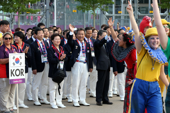 메달 10개 이상을 따내 종합 순위 10위 안에 드는 것을 목표로 한 한국 선수단이 26일 새벽(한국시간) 영국 런던올림픽 광장에서 열린 입촌식에서 손을 들어 인사하고 있다. 연합뉴스