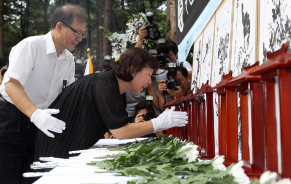 우면산 산사태 희생자 1주기 추모식이 27일 오전 방배동 신동아 아파트 맞은편 우면산 입구에서 열렸다. 추모식에 참석한 유가족이 분향후 오열하고 있다.  연합뉴스
