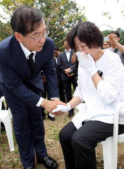 우면산 산사태 희생자 1주기 추모식이 27일 오전 방배동 신동아 아파트 맞은편 우면산 입구에서 열렸다. 박원순 서울시장이 추모식 후 유가족을 위로하고 있다. 연합뉴스