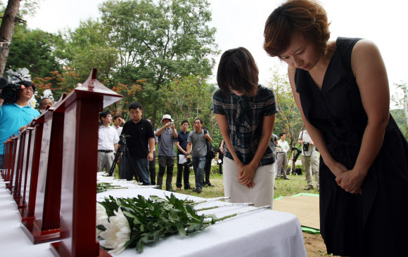 27일 오전 서울 서초구 우면산에서 열린 ‘우면산 산사태 제1주기 추모식’에서 유족들이 빈소에 헌화하고 명복을 빌고 있다. 연합뉴스