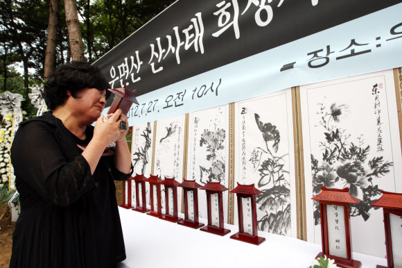 27일 오전 서울 서초구 우면산에서 열린 ‘우면산 산사태 제1주기 추모식’에서 한 유가족이 오열하고 있다. 연합뉴스