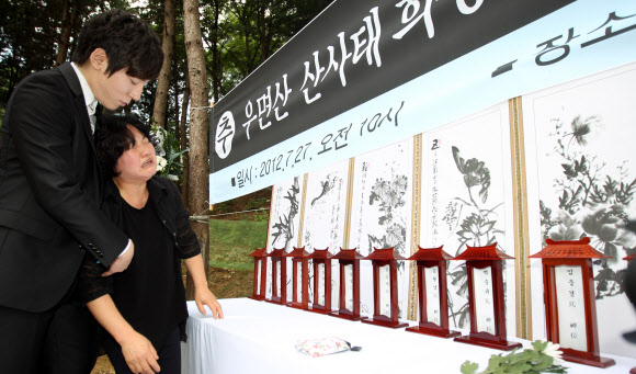우면산 산사태 1주기 추모식이 27일 오전 방배동 신동아 아파트 맞은편 우면산 입구에서 열렸다. 한 유가족이 분향 후 오열하고 있다. 연합뉴스