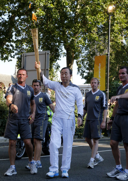 2012런던 올림픽 성화주자로 나선 반기문 유엔 사무총장이 26일 런던 행정구역 웨스트민스터에서 성화를 들고 군중에게 인사를 하고 있다.   연합뉴스