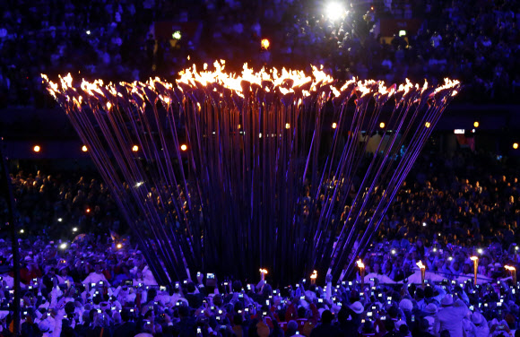 지구촌 최대 스포츠축제가 될 제30회 런던하계올림픽이 28일 영국 런던 북동부 리밸리의 올림픽스타디움에서 화려한 막을 올렸다. ‘경이로운 영국(Isles of Wonder)’이라는 주제로 열린 개막식은 대니 보일 감독이 연출을 맡아 산업화의 진통에서 회복해 미래를 바라보는 농촌의 이야기를 담았다. 성화가 활활 불타오르고 있다. 런던 연합뉴스