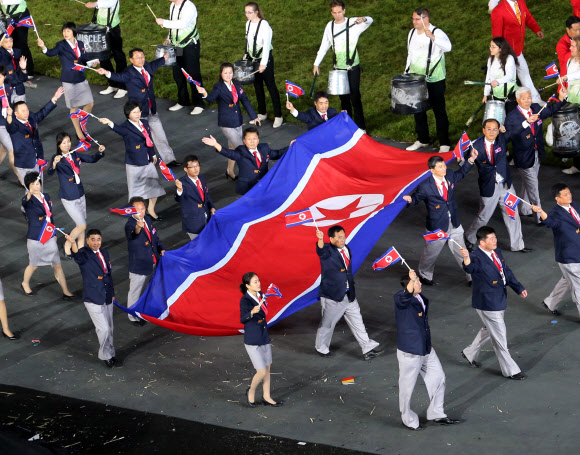 지구촌 최대 스포츠축제가 될 제30회 런던하계올림픽이 28일 영국 런던 북동부 리밸리의 올림픽스타디움에서 화려한 막을 올렸다. 개막식에서 인공기를 든 마라토너 박성철 선수를 선두로 북한선수단이 입장하고 있다. 런던 연합뉴스