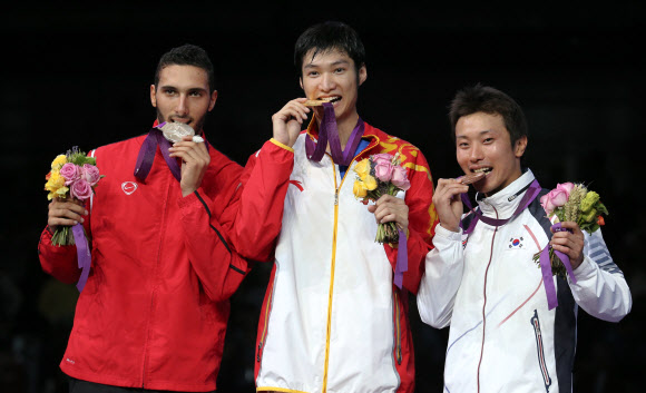 남자 펜싱 플뢰레에서 동메달을 딴 한국의 최병철(오른쪽)이 31일 저녁(현지시각) 런던 엑셀 런던 사우스 홀에서 열린 시상식에서 금메달을 딴 중국의 레이성(가운데), 은메달 이집트의 알라에딘 아부엘카셈과 함께 시상대에서 메달을 깨물어 보고 있다. 올림픽사진공동취재단