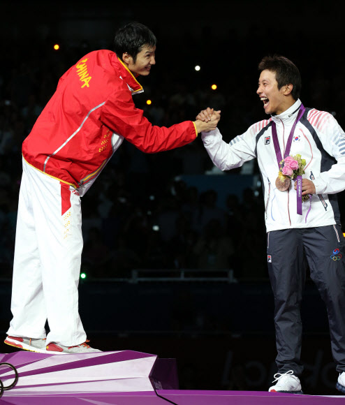 남자 펜싱 플뢰레에서 동메달을 딴 한국의 최병철이 31일 저녁(현지시각) 런던 엑셀 런던 사우스 홀에서 열린 시상식에서 시상대에 올라 금메달을 딴 중국의 레이성과 악수하고 있다. 올림픽사진공동취재단