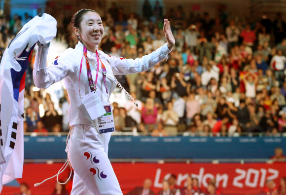 한국 펜싱의 신아람이 5일 영국 런던 엑셀 노스아레나2에서 열린 런던올림픽 여자 에페 단체전에서 은메달을 따낸 뒤 환한 표정으로 태극기를 들고 환호에 답하고 있다. 런던 올림픽사진공동취재단