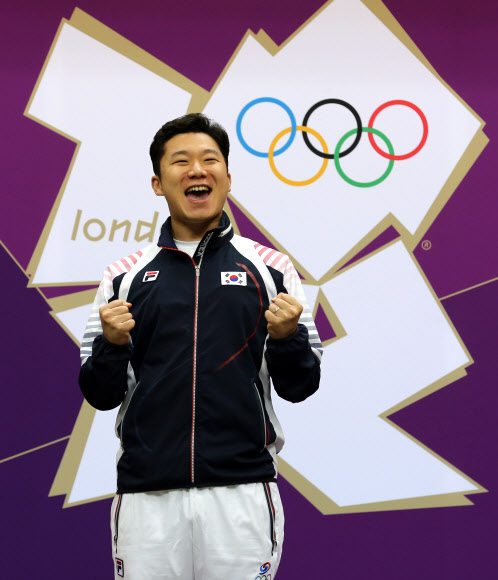 2012 런던올림픽에서 남자 50ｍ 권총 2연패를 달성한 진종오(KT)가 5일 오후(한국 시간) 영국 런던 그리니치파크의 왕립 포병대 기지 사격장에서 우승을 차지한 후 시상대에 올라서며 환호하고 있다.  연합뉴스