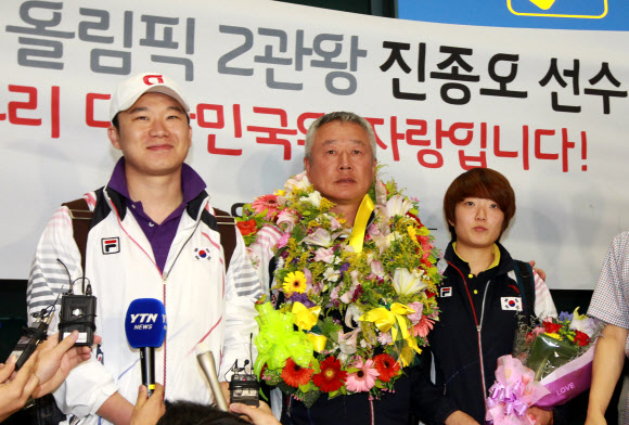 런던올림픽 사격 2관왕 진종오와 김장미가 8일 오후 영종도 인천국제공항을 통해 귀국한 뒤 취재진과 인터뷰를 하고 있다. 가운데는 사격 대표팀 변경수 감독.  연합뉴스