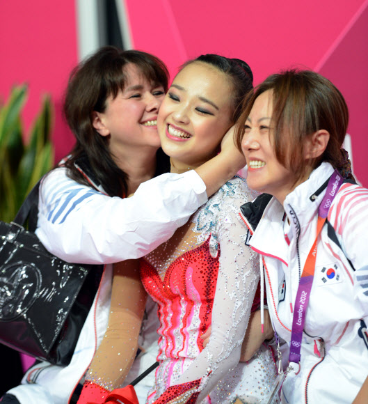 2012 런던올림픽 체조대표팀의 손연재가 10일(현지시간) 런던 웸블리 아레나에서 열린 리듬체조 개인종합 예선에서 리본 연기를 마친 뒤 코치인 옐레나 니표도바와 밝은 표정을 보이고 있다. 손연재는 앞서 9일 오후 열린 후프와 볼 종목에서 중간 합계 55.900점으로 24명의 예선 참가 선수 중 4위에 올라 한국체조대표팀 사상 첫 결선 진출의 꿈을 이룰 수 있을 지 기대를 한몸에 받고 있다. 올림픽사진공동취재단