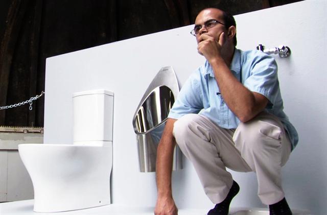 빌앤드멀린다게이츠재단의 ‘화장실 재발명 프로젝트’의 지원을 받고 있는 캘리포니아공과대(칼텍)의 박사후연구원 클레멘트 시드가 자신이 개발한 태양광 발전 화장실에 앉아 있다.  칼텍 제공