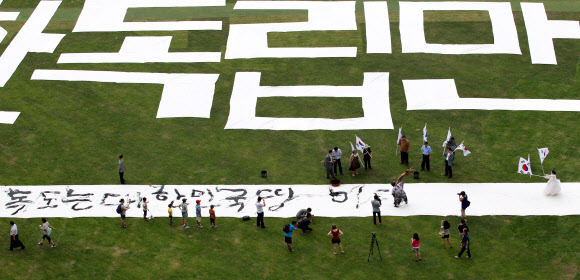 광복절을 하루 앞둔 14일 오후 서울광장에서 한국 서예 퍼포먼스 김동욱 고문이 독도 퍼포먼스를 하고 있다. 연합뉴스