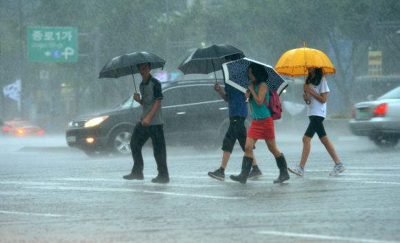 중부지방에 폭우가 내린 15일 서울 광화문에서 우산을 쓴 시민들이 굵은 빗줄기가 쏟아지는 가운데 길을 건너고 있다. 손형준기자 boltagoo@seoul.co.kr