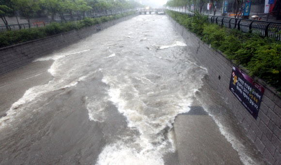 광복절인 15일 서울시 종로구 서린동 일대 청계천 산책로가 물에 잠겨 있다. 연합뉴스
