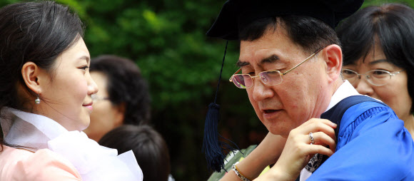 17일 오전 용산구 숙명여자대학교를 졸업한 학생이 아버지에게 학사복을 입혀주고 있다. 연합뉴스