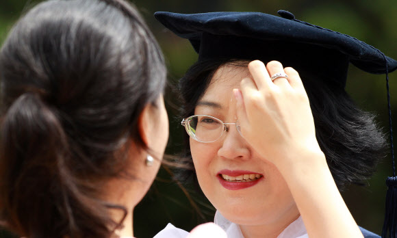 17일 오전 용산구 숙명여자대학교를 졸업한 학생이 어머니에게 학사모를 씌워주고 있다. 연합뉴스