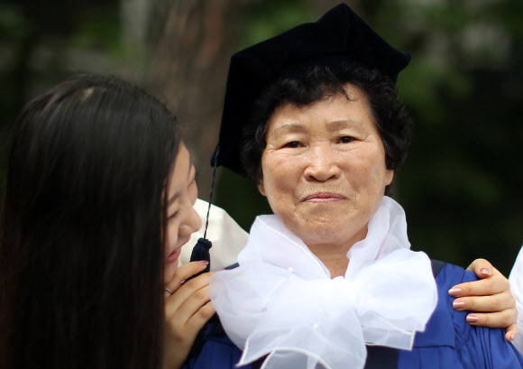 17일 오전 용산구 숙명여자대학교 졸업식에서 손녀 딸의 학사복을 입은 한 할머니가 경직된 채 카메라를 바라보고 있다. 연합뉴스