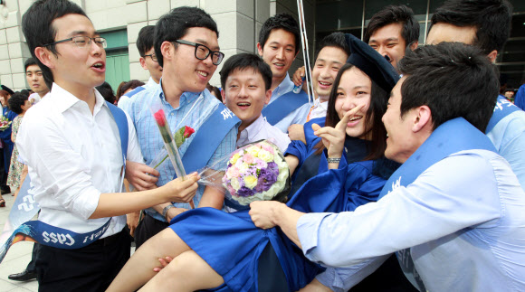 17일 오전 서울 용산구 숙명여대에서 코스모스 졸업을 맞은 한 학생이 동료들에게 축하받고 있다. 연합뉴스