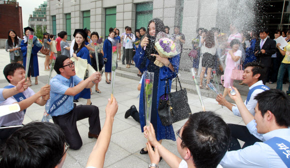 17일 오전 서울 용산구 숙명여대에서 코스모스 졸업을 맞은 한 학생이 동료들에게 축하받고 있다.  연합뉴스