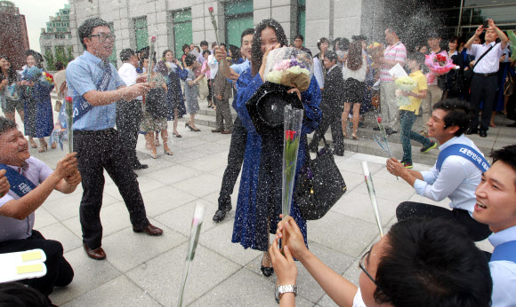 17일 오전 서울 용산구 숙명여대에서 코스모스 졸업을 맞은 한 학생이 동료들에게 축하받고 있다. 연합뉴스
