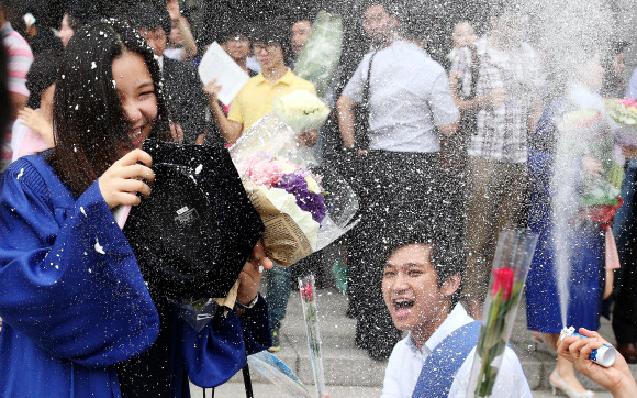 17일 오전 용산구 숙명여자대학교에서 졸업식을 마치고 나오는 한 학생이 회사 동료들의 축하를 받고 있다. 연합뉴스