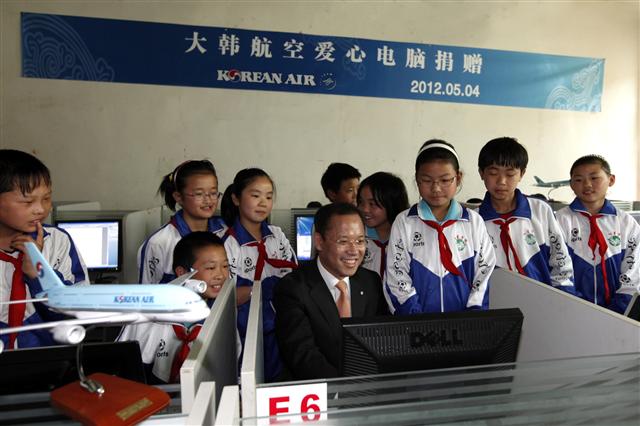박인채(가운데) 대한항공 중국 지역 본부장이 지난 5월 베이징 훙싱초등학교에서 열린 컴퓨터 70대 기부 행사를 마치고 새로 마련된 전산실에서 학생들과 함께 컴퓨터를 작동해 보고 있다. 대한항공 제공