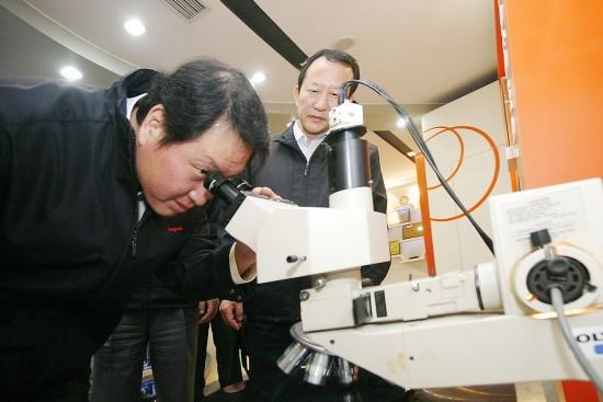 최태원(왼쪽) SK그룹 회장이 지난 2월 하이닉스 중국 공장을 방문해 현미경으로 반도체 회로를 살펴보고 있다. SK그룹 제공