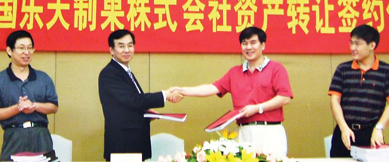 롯데제과 김용수(왼쪽 두번째) 대표가 낙천상해식품유한공사 대표와 인수 협약에 서명한 뒤 악수하고 있다. 롯데제과 제공