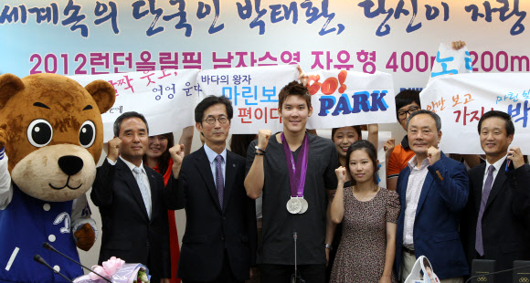 21일 오전 모교인 경기도 용인 단국대를 찾은 2012 런던 올림픽 수영 은메달리스트 박태환 선수가 메달을 목에 걸고 학교 관계자, 학생과 함께 파이팅을 외치고 있다. 연합뉴스