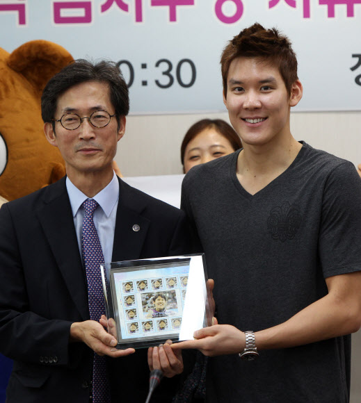 21일 오전 모교인 경기도 용인 단국대를 찾은 2012 런던 올림픽 수영 은메달리스트 박태환 선수가 단국대 김병량 기획ㆍ대외부총장으로부터 자신을 모델로 한 우표 선물을 받고 있다. 연합뉴스