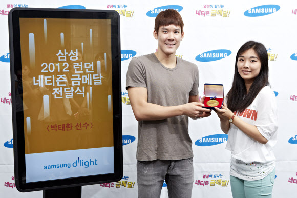 박태환 선수가 지난 20일 서울 서초동 삼성 딜라이트에서 진행된 ‘네티즌 금메달 전달식’에 참석해 그를 응원하는 댓글을 올린 네티즌으로부터 네티즌 금메달과 네티즌 응원 메시지가 담긴 기념 액자를 받고 있다. 삼성 제공