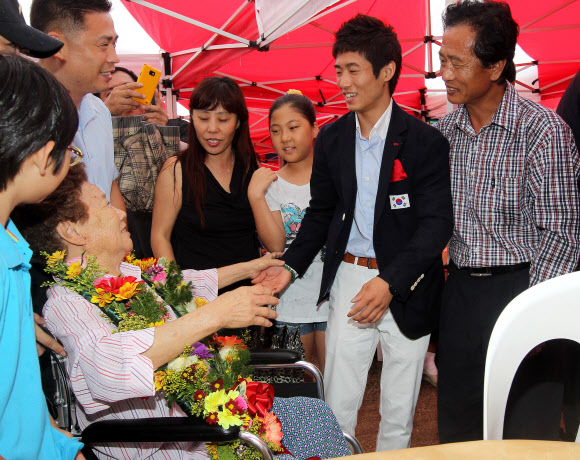 런던올림픽 남자체조 금메달을 딴 양학선이 22일 전북 고창군 공음면 남동마을에서 열린 환영식에 참석, 할머니를 비롯한 친지와 함께 인사하고 있다. 연합뉴스
