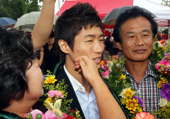 런던올림픽 남자체조 금메달을 딴 양학선이 22일 전북 고창군 공음면 남동마을에서 열린 환영식에서 어머니 기숙향(왼쪽)씨가 얼굴에 뽀뽀를 한 후 흔적을 지우고 있다. 연합뉴스