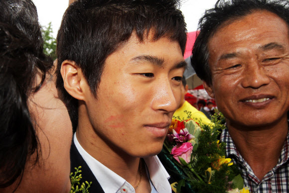 런던올림픽 남자체조 금메달을 딴 양학선이 22일 전북 고창군 공음면 남동마을에서 열린 환영식에서 어머니 기숙향(왼쪽)씨로부터 얼굴에 뽀뽀 자국이 얼굴에 선명하다.오른쪽은 아버지. 연합뉴스