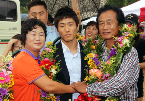 런던올림픽 남자체조 금메달을 딴 양학선이 22일 전북 고창군 공음면 남동마을에서 열린 환영식에 참석, 부모와 손을 맞잡고 있다. 연합뉴스