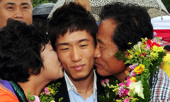 런던올림픽 남자체조 금메달을 딴 양학선이 22일 전북 고창군 공음면 남동마을에서 열린 환영식에 참석, 부모로부터 뽀뽀를 받고 있다. 연합뉴스