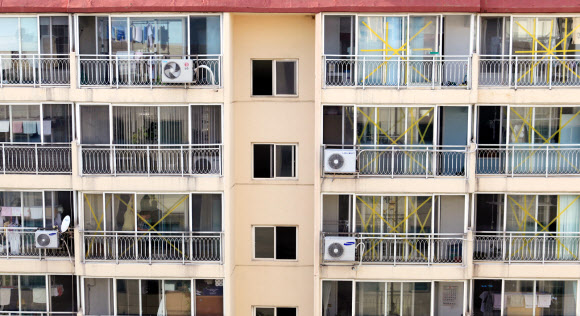 제15호 태풍 ‘볼라벤(BOLAVEN)’이 북상 중인 가운데 26일 오후 목포시 공무원들이 옥암동 금호 아파트 유리창에 테이프를 붙이고 있다. 이 아파트는 태풍 내습 때 강풍에 대형 유리창이 깨지는 피해를 봤다. 상자 테이프를 이용, 가로 세로로 붙이거나 신문지에 물을 묻혀 붙여 놓으면 강풍에도 유리창이 깨지지 않고 잘 버틴다. 시는 강풍에 파손 위험이 있는 일부 아파트에서 테이핑 작업을 했다. 연합뉴스