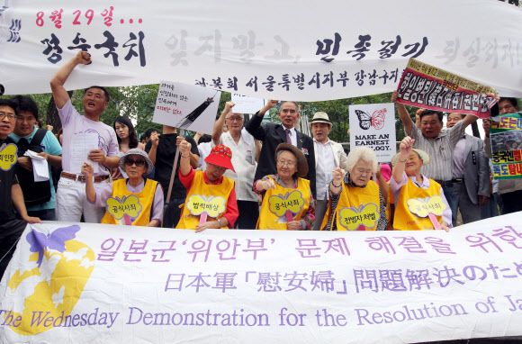 경술국치 102주년을 맞은 29일 서울 종로구 중학동 일본대사관 앞에서 한국정신대문제대책협의회(정대협) 주최로 열린 위안부 문제 해결을 촉구하는 1천37번째 수요집회에서 할머니들과 참가자들이 구호를 외치고 있다.  연합뉴스