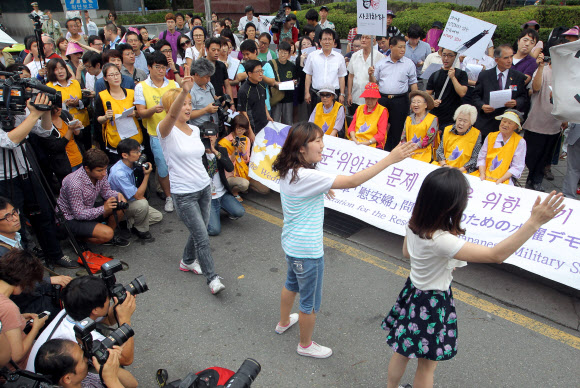 경술국치 102주년을 맞은 29일 서울 종로구 중학동 일본대사관 앞에서 한국정신대문제대책협의회(정대협) 주최로 열린 위안부 문제 해결을 촉구하는 1천37번째 수요집회에서 할머니들이 공연을 보고 있다.  연합뉴스