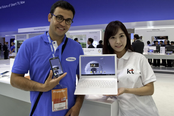 KT는 독일 베를린에서 열린 유럽 최대 가전전시회 ‘IFA 2012’에서 갤럭시S3와 연결해 이메일, 문서작업, 게임, 영상 등을 즐길 수 있는 ‘스파이더 랩탑’을 공개했다. 사진은 IFA 삼성전시홀에서 KT와 삼성의 현장 안내도우미가 스파이더 랩탑과 갤럭시S3를 선보이고 있는 모습.   사진-KT